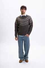 Buzo de tejido de punto en color marrón con diseño jacquard geométrico en la parte superior del pecho y hombros. Presenta cuello redondo, mangas largas y puños acanalados.