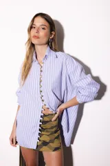 Camisa oversize a rayas celestes y blancas, con cuello camisero, manga larga y hilera de botones dorados metálicos.
