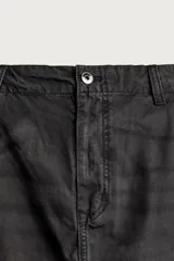 Pantalón cargo de corte relaxed fit, color negro con efecto lavado y estampado de salpicaduras blancas. Cuenta con bolsillos laterales con solapa en las perneras, pinzas en las rodillas y cierre frontal con botón y cremallera.