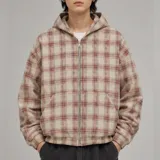 Campera con capucha y cierre frontal completo, con diseño a cuadros en tonos beige y bordó, bolsillos frontales tipo canguro y elástico en puños y cintura.