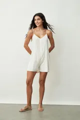 Monoprenda corta de tirantes finos con estampado de piel de serpiente. Presenta un cierre frontal con botones y un diseño ajustado en la parte superior con short holgado.