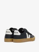 Zapatillas Veja modelo Recife, de cuero negro con cierre de tres tiras de velcro. Presenta el logo de la marca en blanco en el lateral, detalle blanco en el talón y suela de goma color caramelo.
