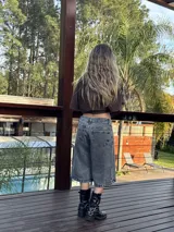 Bermuda de jean gris oscuro con lavado gastado, corte ancho y largo a la rodilla.