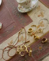 Anillo dorado con diseño irregular que simula un pétalo.