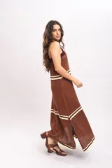 Vestido largo de tejido de punto color marrón, con tirantes anchos, escote cuadrado con detalles en tono bordó y franjas horizontales en color crema con terminación ondulada.
