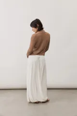 Falda larga color marrón, con diseño drapeado en la cintura de tiro bajo y corte amplio y fluido con vuelo.