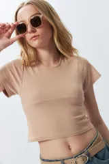 Top corto negro ajustado al cuerpo, de manga corta y cuello redondo.