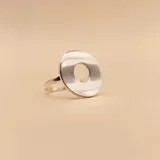 Anillo de plata 925 con diseño de doble banda que conecta un círculo plano grande con un dije circular pequeño grabado.