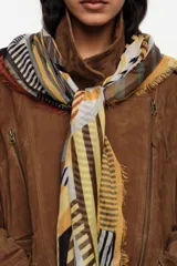Chal de viscosa liviano con diseño multicolor de bloques geométricos y letras estampadas, con terminaciones desflecadas en los bordes.
