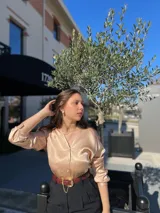 Camisa color beige de mangas largas con puños abotonados y cuello camisero.