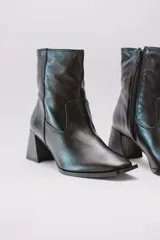 Botas cortas de cuero color crema, con cierre lateral y taco cuadrado. Forro, capellada y plantilla 100% cuero.