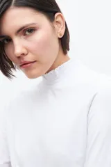 Remera de manga larga color blanco, con cuello alto con volados.