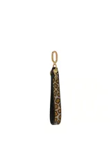 Llavero de muñeca con correa delgada de cuero sintético negro y estampado animal print de leopardo, con herrajes dorados y dije con logo de la marca.