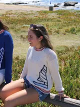 Sweater tejido a mano en lana merino o hilo de algodón, con cuello redondo y diseño de velero en el frente.