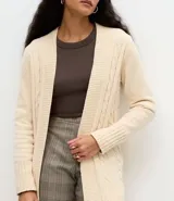 Cardigan abierto de largo medio, confeccionado en punto texturizado con diseño de cables marcados y puños acanalados.