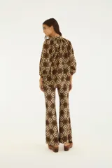 Pantalón acampanado marrón con estampado floral y geométrico, de tiro medio y calce ajustado en la parte superior.
