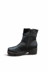 Bota corta de cuero color marrón con suela track y taco bloque. Incluye una tira decorativa en el tobillo con hebilla metálica dorada.