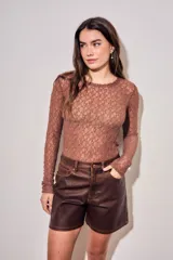 Remera de encaje negro ajustada al cuerpo, de manga larga y diseño transparente.