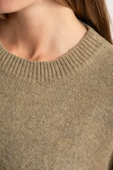 Sweater de lana de corte oversize, con cuello redondo y mangas largas con puños acanalados. Diseño de tejido liso en tono neutro.