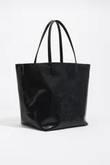 Bolso tipo shopper de tamaño grande confeccionado en cuero reciclado color negro, con acabado brillante, doble asa de hombro y logo de la marca grabado en el frente.