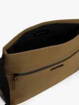 Cartera mensajera color marrón con correa de tela negra con el logo de Tommy Hilfiger. Tiene dos bolsillos con cremallera, uno principal y otro interior.