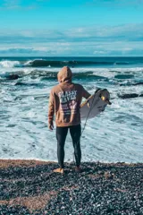 Buzo hoodie marrón con capucha y cordones ajustables. Estampado en la espalda con la frase "Glassy Waves", "Good Vibes" y una flor.