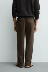 Pantalón de corte regular fit confeccionado en tejido mezcla de algodón, con cintura elástica ajustable mediante cordón, bolsillos laterales y bolsillos traseros de vivo.