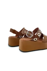 Sandalia de cuero color marrón con plataforma y ajuste con hebilla.