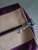 Bolso de lona color verde militar con detalles en cuero marrón. Tiene doble asa de mano y correa de hombro ajustable y extraíble.