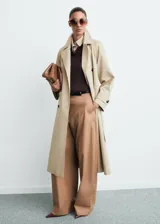 Trench coat de corte recto y diseño oversize, con cierre de doble botonadura, cuello de solapa ancha, bolsillos laterales y mangas largas con puños abotonados. Incluye cinturón desmontable y forro interior.