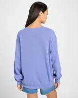 Buzo lila de corte holgado con hombros caídos y estampa frontal con la frase "Brighter Days" en color naranja. Confeccionado en mezcla de algodón y poliéster.