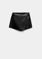 Falda pantalón corta de efecto piel color negro, de tiro medio con diseño cruzado y cierre de cremallera lateral.