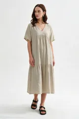 Vestido midi marrón de corte holgado, con escote en V, mangas cortas y detalle de volados fruncidos en el pecho y en el ruedo.