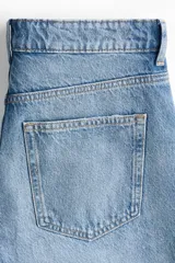 Bermuda de cinco bolsillos en denim de algodón rígido, color celeste con efecto desgastado. Modelo de corte holgado con cierre y botón metálico.