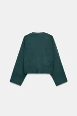 Chaqueta de punto de textura suave en color marrón oscuro, con escote en pico, manga larga y cierre frontal con botones. Presenta dos bolsillos de plastrón en la parte delantera.