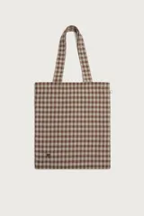 Bolso tipo shopper de la colección Benito Antonio x Zara, confeccionado en tejido con estampado a cuadros en tonos marrones y blancos. Cuenta con compartimento principal sin cierre, doble asa de mano y un pequeño bordado distintivo en la parte inferior.