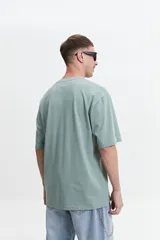 Remera color rosa claro de corte oversize con cuello redondo y mangas cortas. Estampado frontal con un tigre, estrellas y texto "Jungle Army".