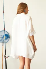 Camisa de corte oversize y diseño holgado, confeccionada en tela de viscosa texturizada. Presenta cuello clásico, cierre frontal con botones de carey y mangas cortas con dobladillo.