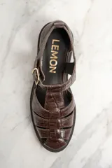 Sandalias cangrejeras de cuero marrón con textura croco, hebilla dorada y suela plana.