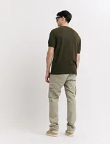 Remera de punto color beige, de manga corta y cuello redondo.