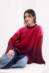 Sweater de punto con diseño en bloques de tonos marrones y tostados, cuello redondo y mangas largas amplias.