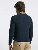 Remera de punto tipo polo con textura waffle, color verde petróleo, de manga larga y cuello con cierre de botones.