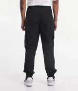 Pantalón jogger color beige, confeccionado en tejido plano de poliamida, con cintura elástica y cordón de ajuste. Presenta múltiples bolsillos cargo con solapa en los laterales y elástico en los puños.