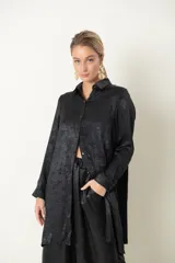 Camisa larga negra con efecto laminado y espalda plisada.