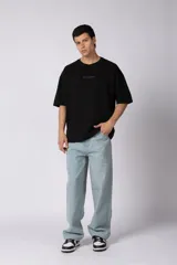 Remerón de corte oversized confeccionado en tejido rústico, con cuello redondo y mangas cortas. Presenta un diseño minimalista con una pequeña estampa frontal centrada en el pecho.