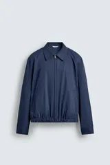 Cazadora regular fit color beige, confeccionada en tejido de algodón. Cuenta con cuello solapa, manga larga con puño elástico y trabilla, bolsillos de vivo en la cadera, bajo elástico y cierre frontal con cremallera.