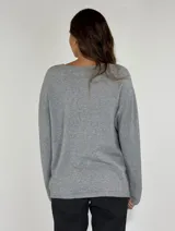 Sweater verde esmeralda de punto con cuello redondo y mangas largas. Presenta un aplique de flores en el ruedo.