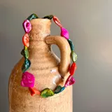 Collar corto elaborado a mano con piedras de nácar naturales en tonos multicolor, que incluyen fucsia, naranja, verde y azul.