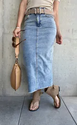 Falda midi de jean celeste con abertura frontal y terminación desflecada.