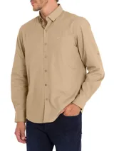 Camisa de manga larga RKF modelo Galiton, color beige, con cuello camisero, cierre frontal de botones y bolsillo en el pecho con logo bordado. Presenta botones en los laterales de las mangas para ajuste y está confeccionada en popelina de algodón orgánico con protección UV.